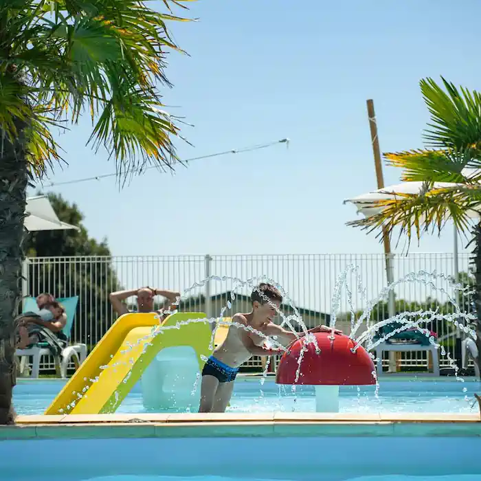 Enfant jouant dans la pataugeoire du camping à Brem-sur-Mer